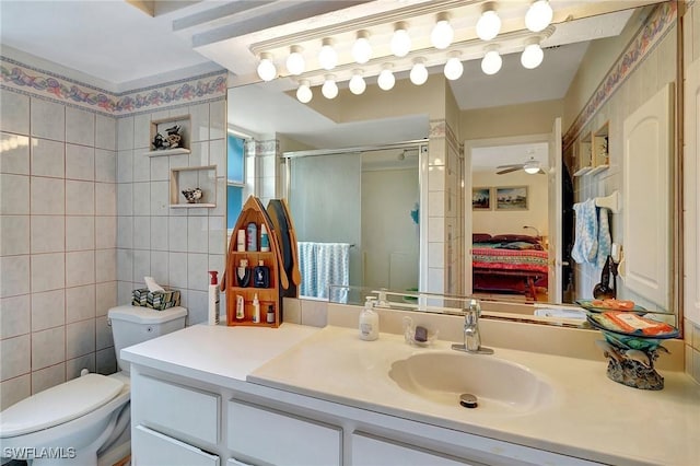 bathroom with walk in shower, vanity, tile walls, and ceiling fan