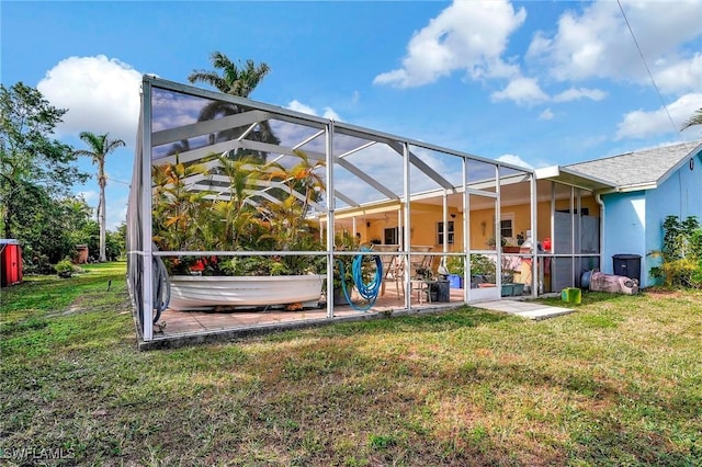 back of property featuring a patio area, a lanai, and a lawn