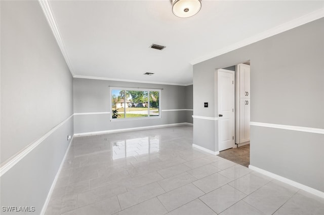 tiled empty room featuring crown molding