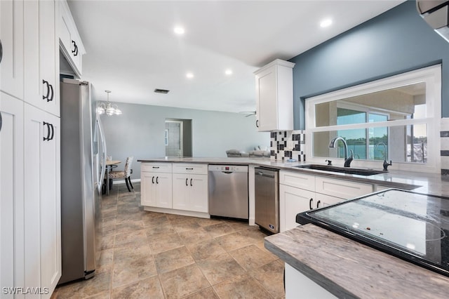 kitchen featuring stainless steel appliances, sink, pendant lighting, and white cabinets