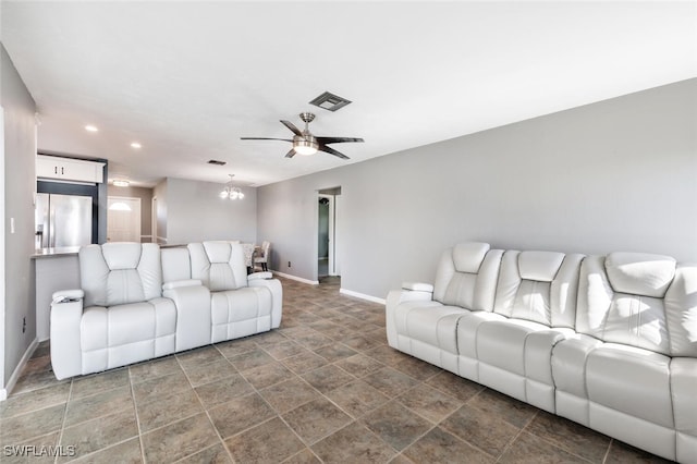 living room featuring ceiling fan with notable chandelier