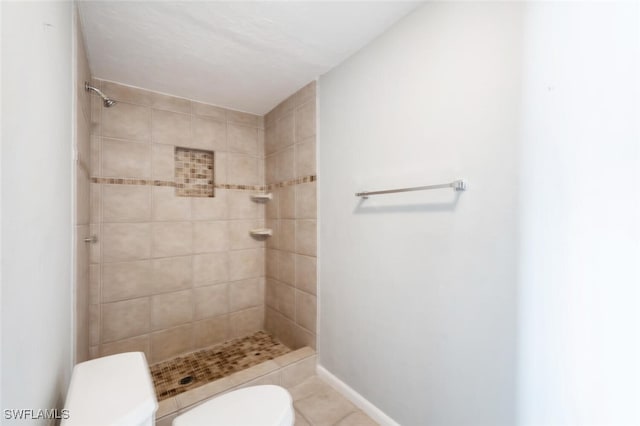 bathroom featuring tiled shower, tile patterned floors, and toilet