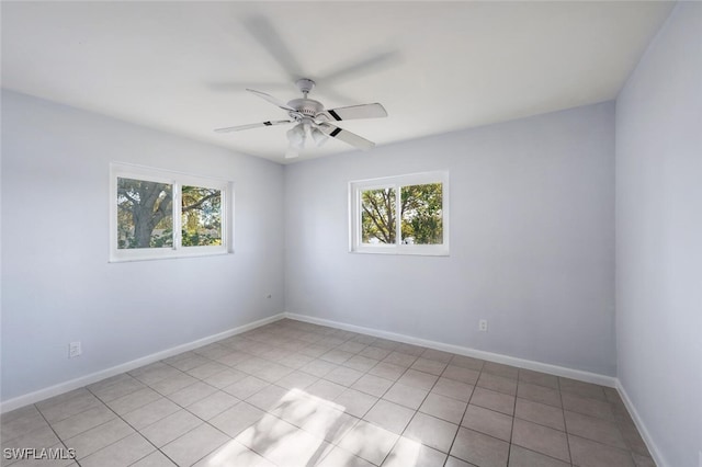 tiled spare room featuring ceiling fan and plenty of natural light