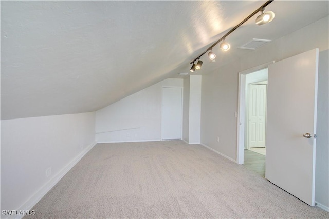 bonus room featuring light colored carpet and lofted ceiling