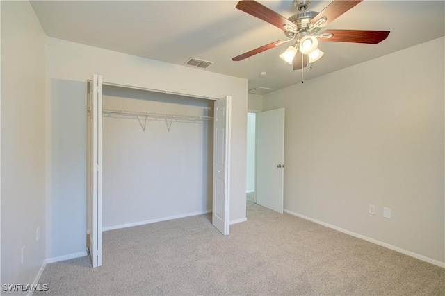 unfurnished bedroom with light colored carpet, a closet, and ceiling fan