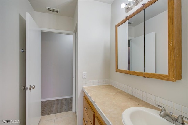 bathroom featuring vanity, tasteful backsplash, and tile patterned flooring