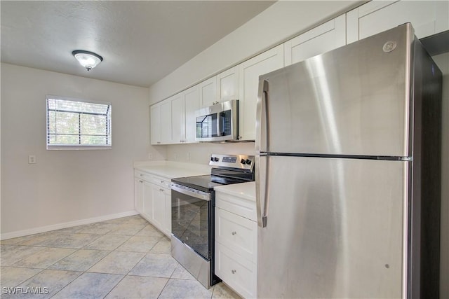 kitchen with white cabinets, stainless steel appliances, and light tile patterned flooring