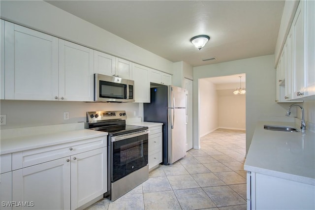 kitchen with sink, white cabinetry, light tile patterned floors, and stainless steel appliances