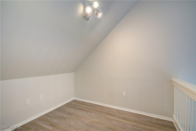 additional living space featuring hardwood / wood-style floors and vaulted ceiling