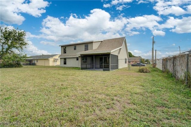 rear view of property with a sunroom and a lawn