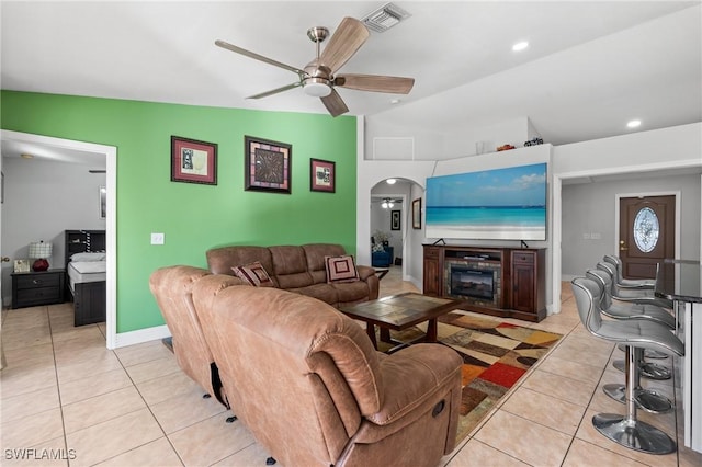 living room with ceiling fan, light tile patterned floors, and vaulted ceiling