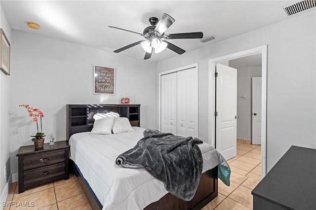 tiled bedroom featuring ceiling fan and a closet