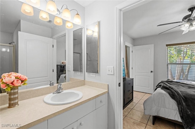 bathroom with tile patterned floors, ceiling fan, a shower with door, and vanity