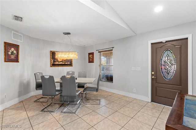 dining area with light tile patterned flooring, vaulted ceiling, and a notable chandelier