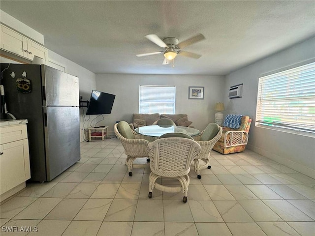 dining room with a textured ceiling, a wall unit AC, a ceiling fan, and baseboards