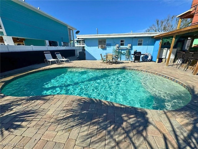 view of swimming pool featuring grilling area, cooling unit, and a patio