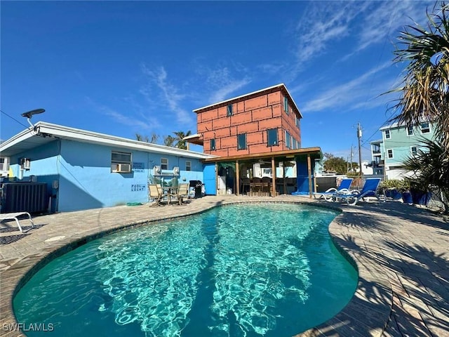 view of pool featuring central AC unit and a patio