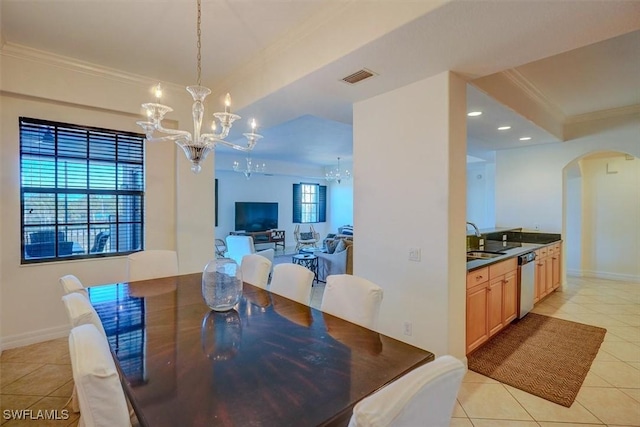 dining room featuring sink, an inviting chandelier, light tile patterned floors, ornamental molding, and a tray ceiling