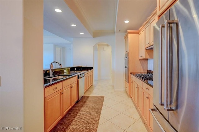 kitchen featuring sink, light tile patterned floors, stainless steel appliances, ornamental molding, and light brown cabinetry