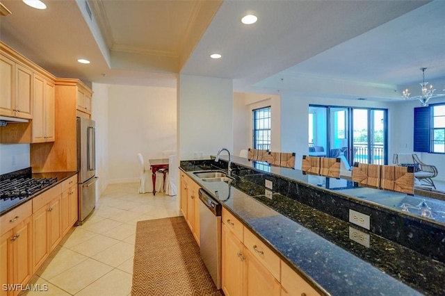 kitchen with sink, light brown cabinets, a tray ceiling, pendant lighting, and stainless steel appliances