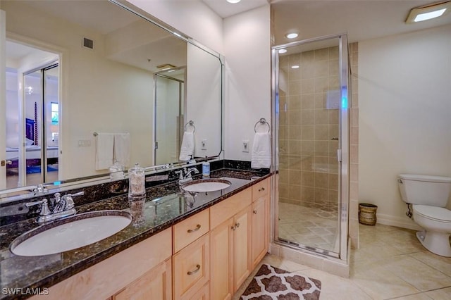 bathroom with vanity, toilet, a shower with shower door, and tile patterned flooring