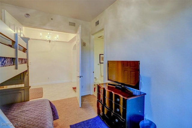 bedroom with light tile patterned floors and a notable chandelier