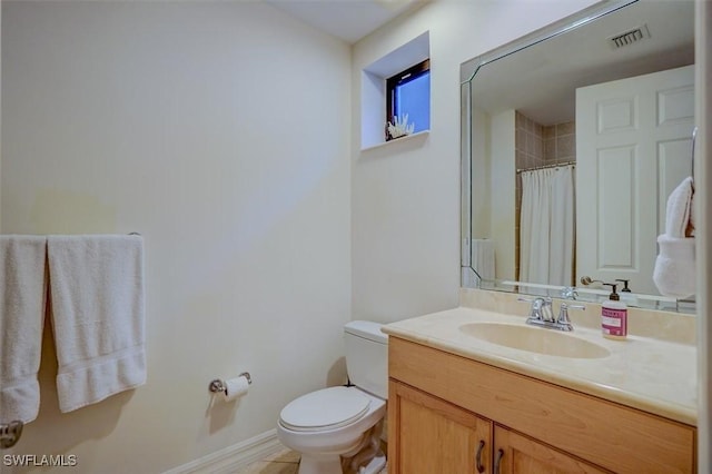 bathroom featuring vanity, walk in shower, and toilet