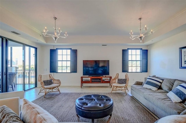 living room with light tile patterned flooring, ornamental molding, a raised ceiling, and a notable chandelier