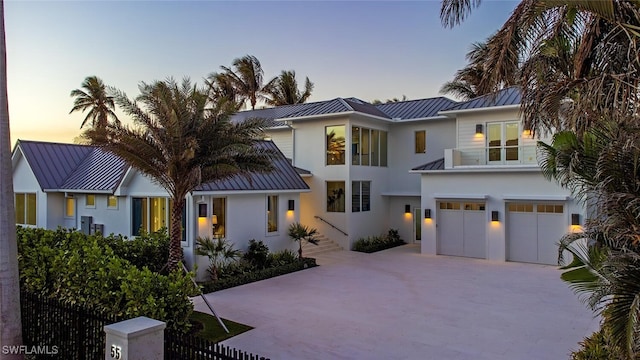 55 13th Ave S, Naples, FL 34102 - contemporary home with a standing seam roof, metal roof, stucco siding, a garage, and driveway