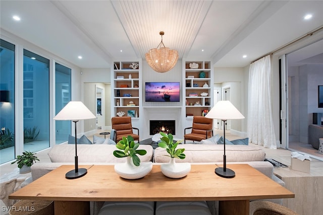 living room featuring built in shelves and an inviting chandelier