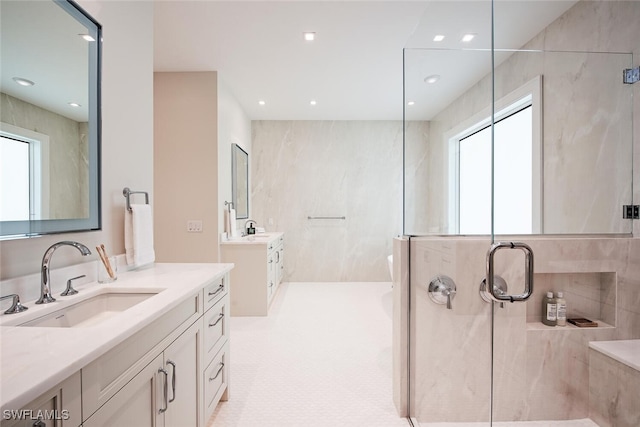 55 13th Ave S, Naples, FL 34102 - bathroom with plenty of natural light, a shower with door, two vanities, and recessed lighting