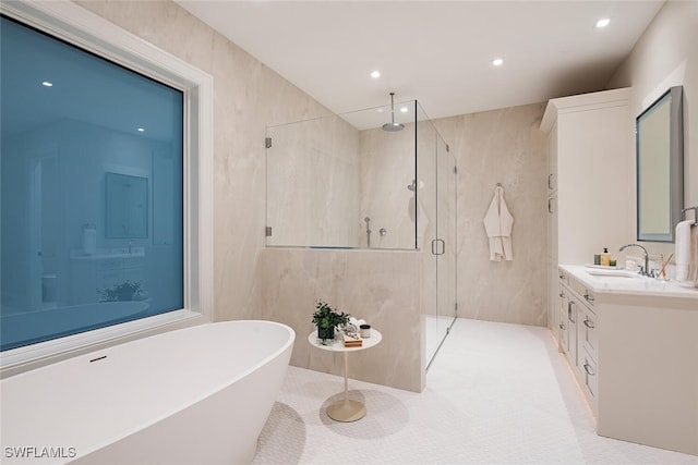55 13th Ave S, Naples, FL 34102 - bathroom with a marble finish shower, vanity, a freestanding tub, recessed lighting, and tile walls