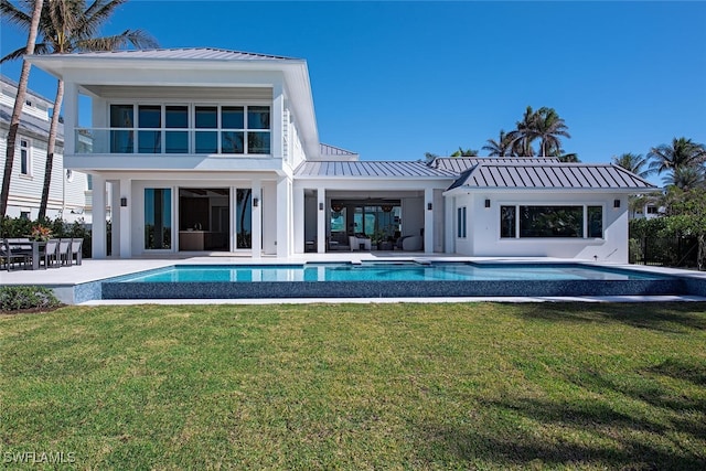 back of house featuring a lawn and a patio