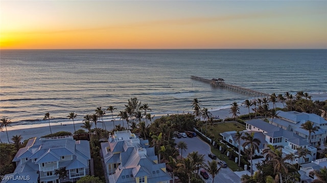 aerial view at dusk featuring a water view