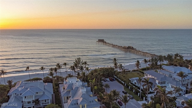 aerial view at dusk featuring a water view