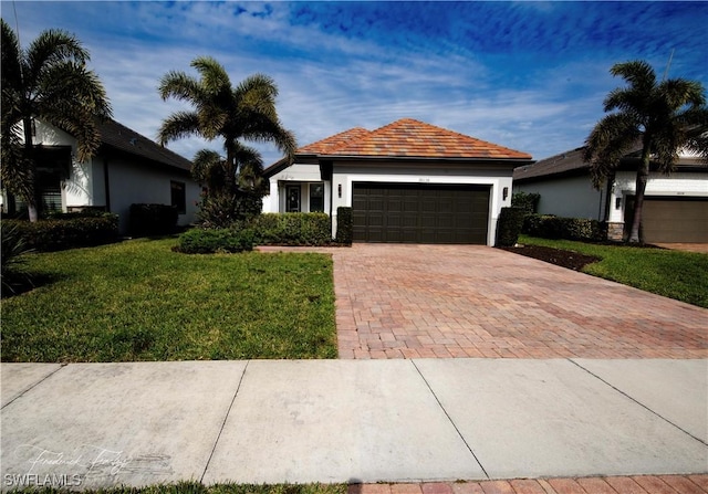 single story home featuring a garage and a front yard