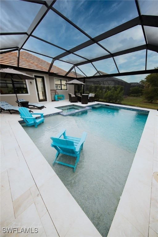 view of pool featuring a lanai, a patio area, and an in ground hot tub