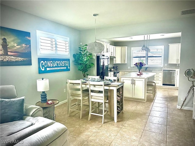 kitchen with a breakfast bar area, a center island, pendant lighting, stainless steel appliances, and white cabinets