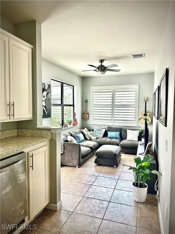 living room featuring light tile patterned floors and ceiling fan