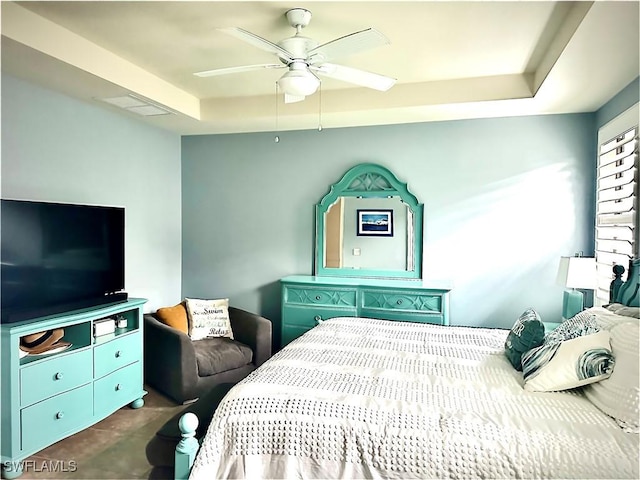 bedroom with ceiling fan and a tray ceiling