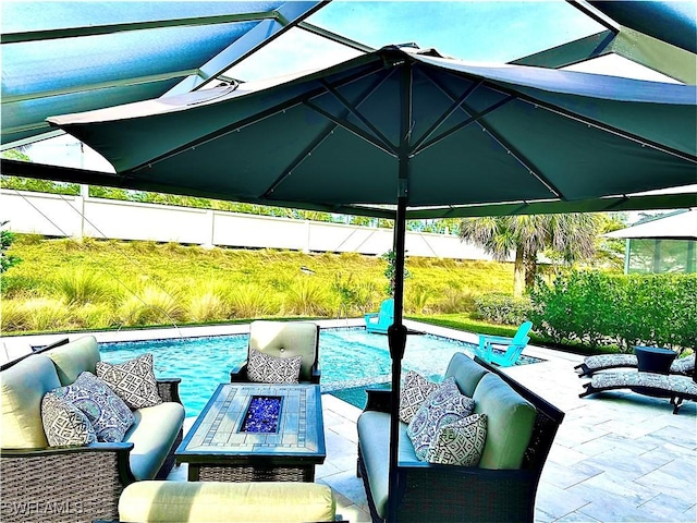 view of patio / terrace with a fenced in pool and an outdoor living space with a fire pit