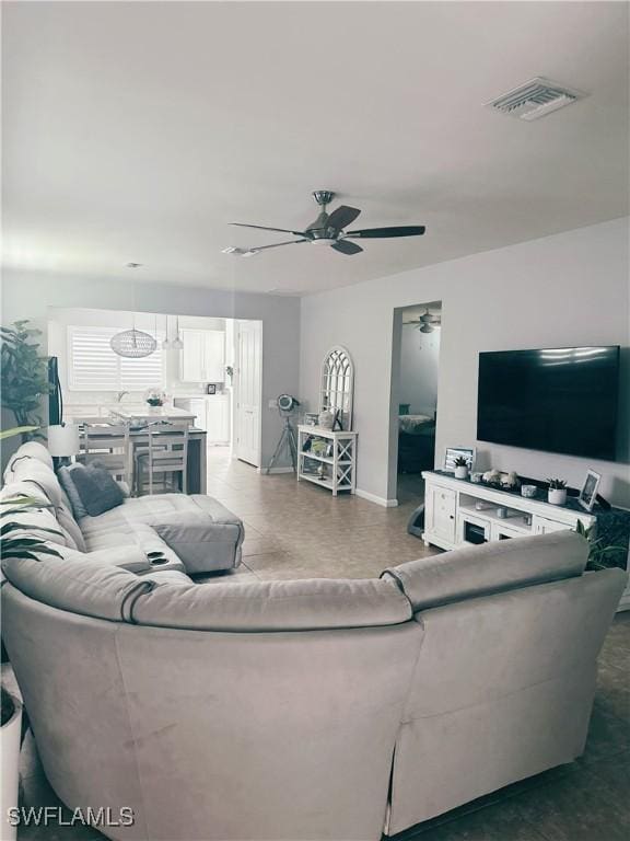 living room featuring a ceiling fan and visible vents