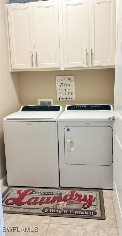 washroom with cabinet space and washer and clothes dryer