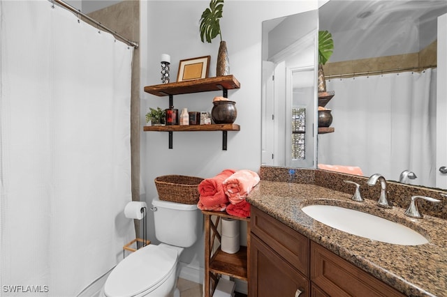 bathroom with toilet, vanity, and walk in shower