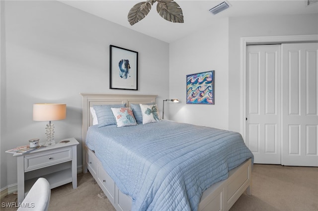 bedroom featuring a closet, light colored carpet, and ceiling fan