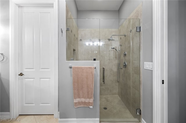 bathroom with an enclosed shower and tile patterned floors