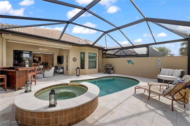 view of pool featuring glass enclosure, a patio area, a bar, and ceiling fan