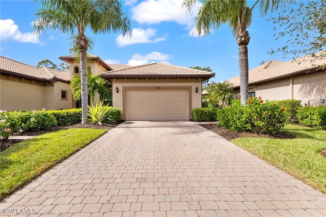 mediterranean / spanish house featuring a front yard and a garage