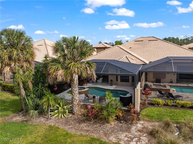 view of swimming pool with a lanai, a patio area, and an in ground hot tub