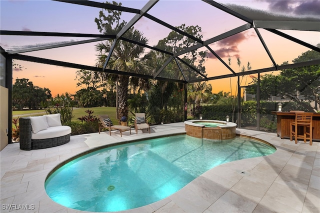 pool at dusk featuring an in ground hot tub, a bar, a patio, and glass enclosure